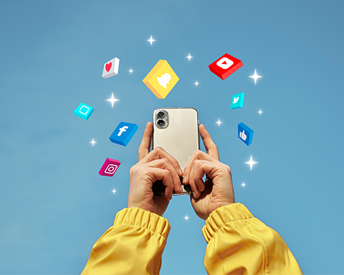 A pair of hands holding an iPhone displaying vibrant social media icons against a soothing baby blue background, symbolizing digital connectivity and engagement.