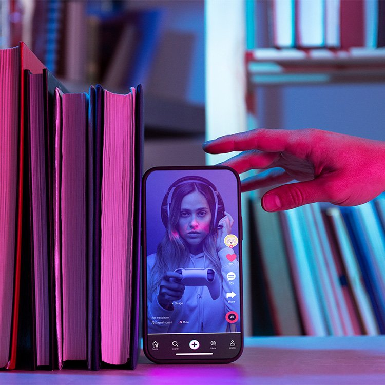 A purple theme with a phone beside books and a girl in a tiktok video inside it.