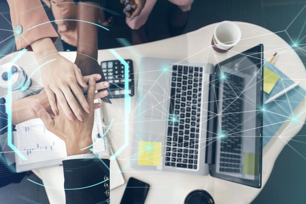 Business people closing up their hands in a meeting with blue hologram in the foreground