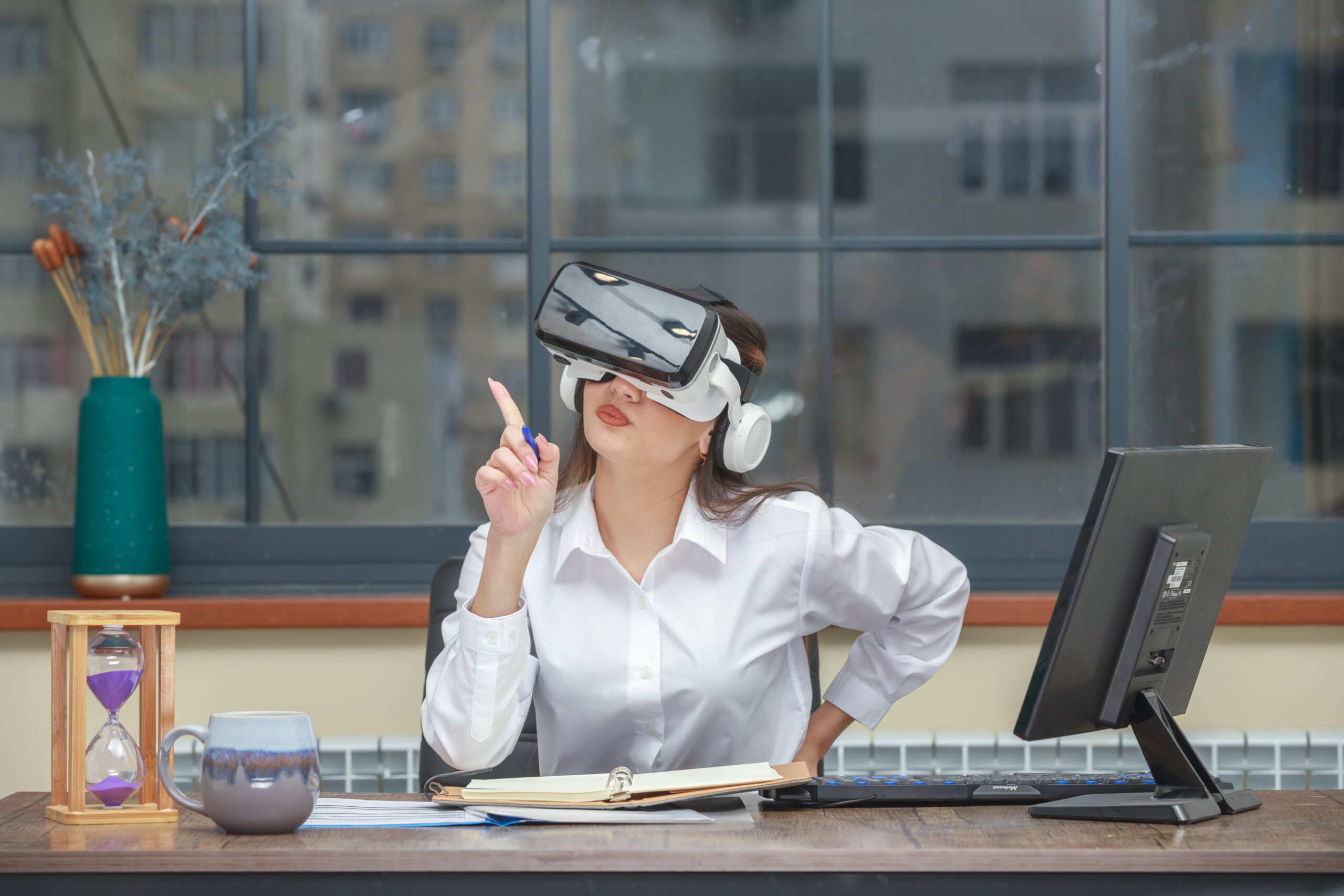 A girl wearing VR and setting on her desk and pointing with her finger